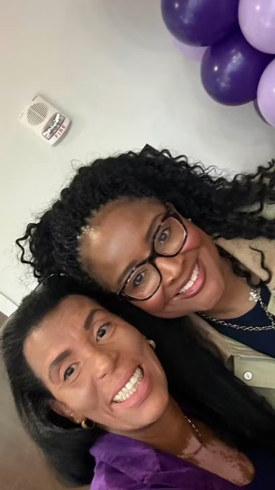 Two community members smiling together at a vitiligo awareness event